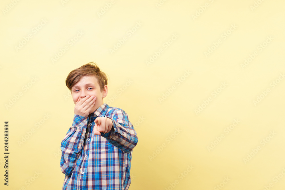 grinning boy mocking and laughing pointing finger at viewer and covering mouth, advertisement, banner or poster template, emotion facial expression, people reaction grinning boy mocking and laughing pointing finger at viewer and covering mouth, advertisement, banner or poster template, emotion facial expression, people reaction