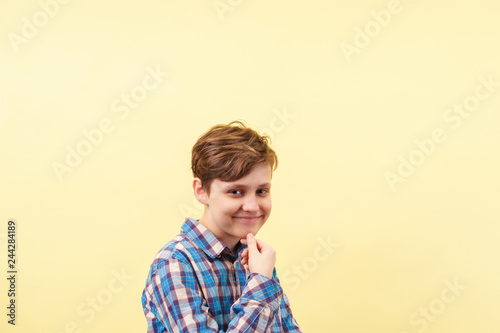 smug cheeky daring boy with skeptical smile over yellow background, advertisement, banner or poster template, emotion, people reaction