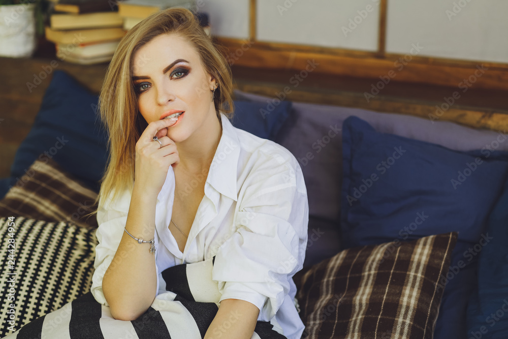Young beautiful blonde girl in a white men's shirt on the bed Young beautiful blonde girl in a white men's shirt on the bed