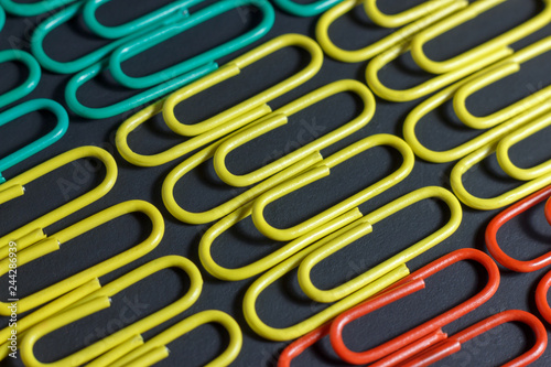 Colorful multicolored paper clips on a black background.