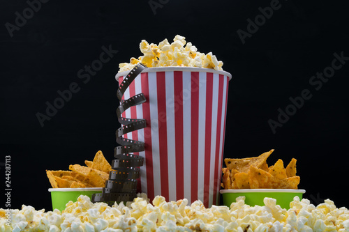 a big paper cup with popcorn and two small ones with chips for the movies
