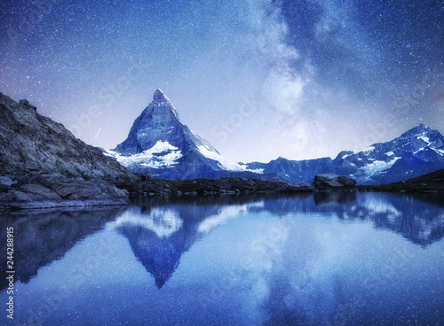 Matterhorn and reflection on the water surface at the night time. Milky way above Matterhorn  Switzerland. Beautiful natural landscape in the Switzerland
