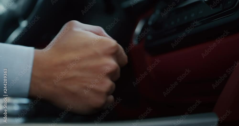 Close up young businessman is driving a new car just bought from auto deal. Slow motion shot in 8K. Concept of passion for driving cars and engines, car dealerships, used cars, luxury cars Close up young businessman is driving a new car just bought from auto deal. Slow motion shot in 8K. Concept of passion for driving cars and engines, car dealerships, used cars, luxury cars