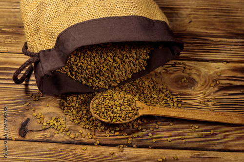 Fenugreek seeds on wooden table photo