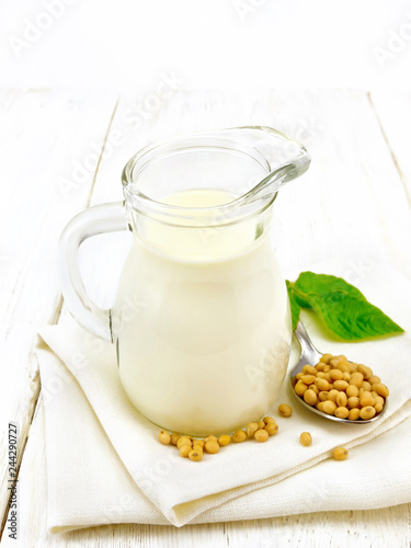 Milk soy in jug with leaf on board