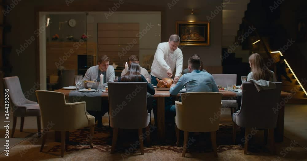 Senior man grandfather cutting turkey for family on thanksgiving dinner. 4K UHD 60 FPS SLOW MOTION Blackmagic RAW Senior man grandfather cutting turkey for family on thanksgiving dinner. 4K UHD 60 FPS SLOW MOTION Blackmagic RAW