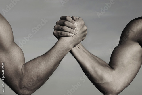 Rivalry, vs, challenge, strength comparison. Two men arm wrestling. Arms wrestling, competition. Rivalry concept - close up of male arm wrestling. Leadership concept. Black and white. photo