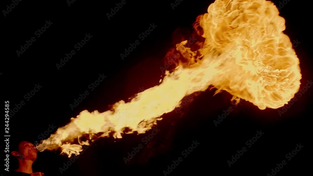 Cool fire show artist breathes fire in dark air, performing amazing stunts - extreme slow motion