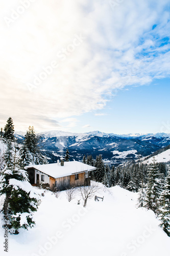 Beautiful hut in the mountains in a Winter sunny day in Austrian Alps. © andremoecke