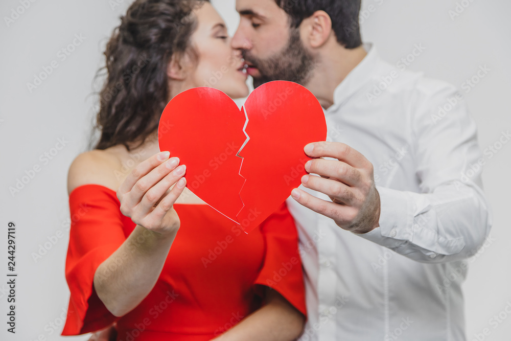 Portrait of an Excessive Couple. Hold two pieces of carded paper and kiss. Women dressed in red men's dresses in a white shirt. Portrait of an Excessive Couple. Hold two pieces of carded paper and kiss. Women dressed in red men's dresses in a white shirt.