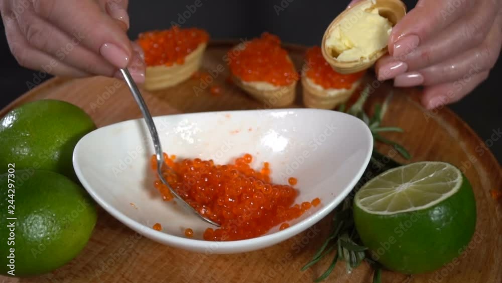Red caviar is put into the waffle tartlet. slow motion Red caviar is put into the waffle tartlet. slow motion