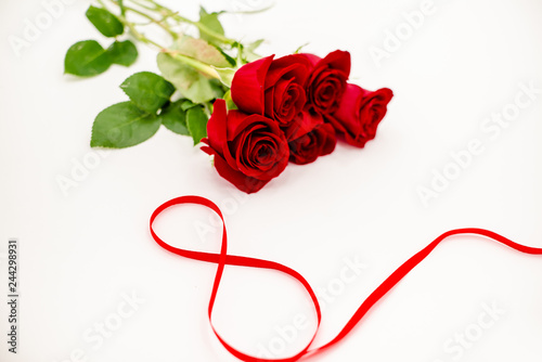 Bouquet of red  roses with a red ribbon. Eights march woman's day, holiday. Flowers on a white background copespace. Horizontal top view, number 8 in a ribbon
