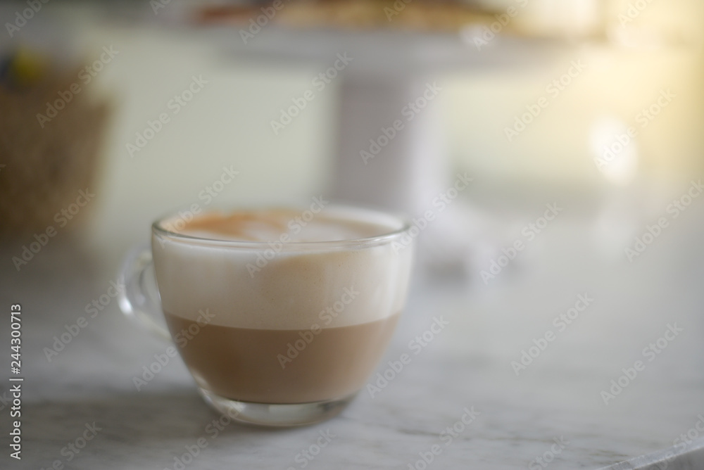 Foamy Cappuccino in a glass cup on a marble table Foamy Cappuccino in a glass cup on a marble table