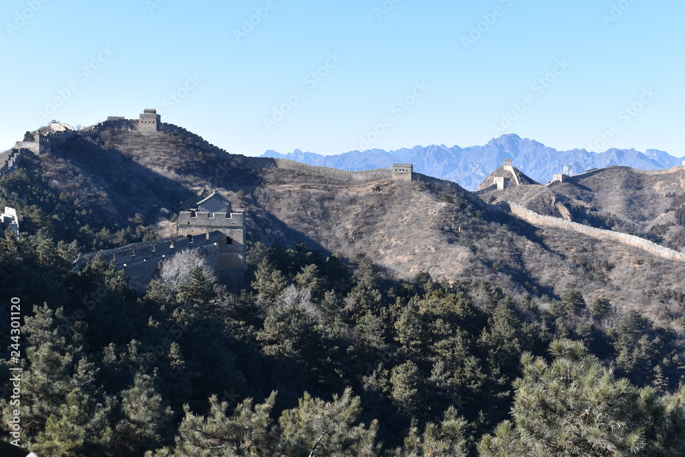 Panorama of the Great Wall in Jinshanling in winter with green trees in front near Beijing in China