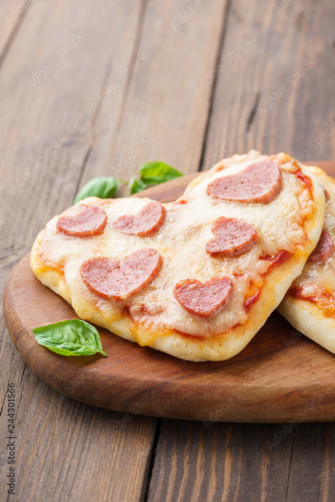 Heart shaped mini pizza with pepperoni, tomatoes and mozzarella.