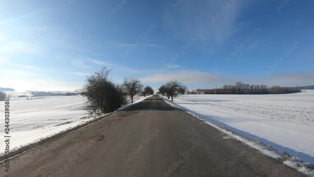 Car driving in through countryside in winter season, sunny day and landscape covered by snow, flat protune colors Car driving in through countryside in winter season, sunny day and landscape covered by snow, flat protune colors