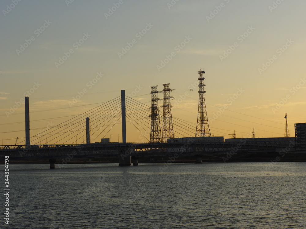 power towers and a bridge at sunset