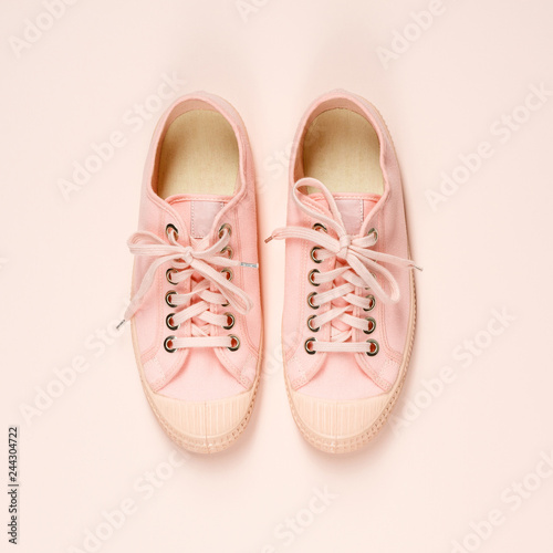 Pink canvas sneakers on pink background, close up