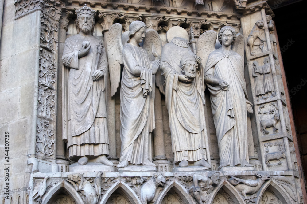 Close up to statues on facade of Notre Dame cathedral, Paris / France