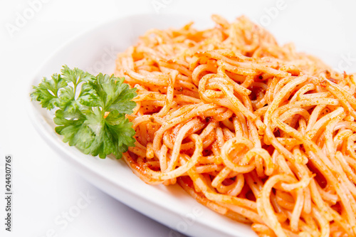 Spaghetti with pesto decorated with parsley on a plate on a white background