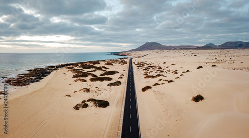 Aerial view of an empty road through the dunes at the sunrise with copy space photo