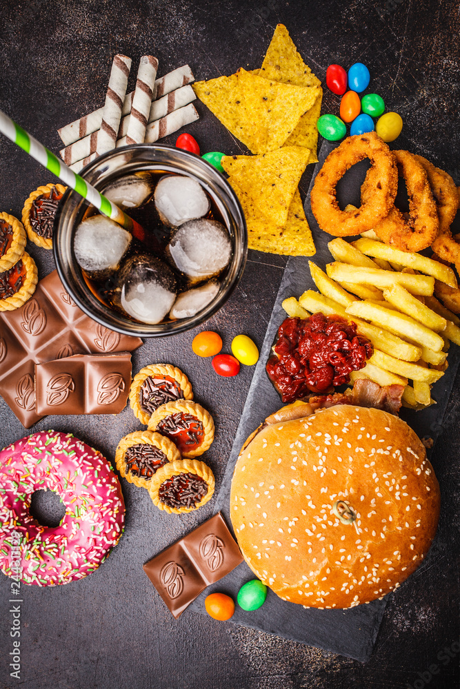 Junk food concept. Unhealthy food background. Fast food and sugar. Burger,  sweets, chips, chocolate, donuts, soda, top view. Stock Photo | Adobe Stock