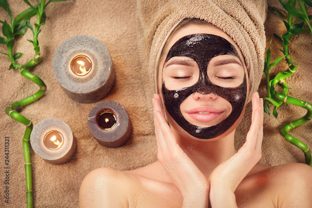 Beautiful woman with black purifying black mask on her face. Beauty model  girl with black facial peel-off mask lying in spa salon. Skincare,  cleansing Stock 写真 | Adobe Stock