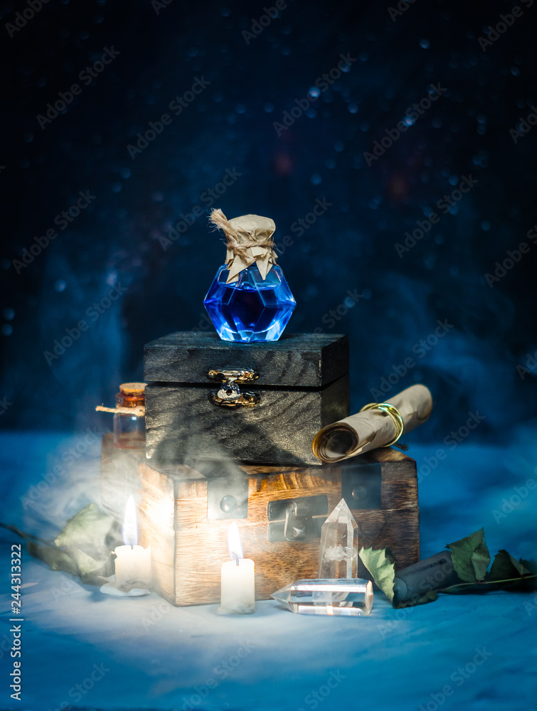 Blue magic potion with smoke on wooden box. Dark magic concept