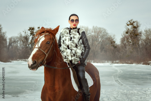 Fashionable woman riding a horse.