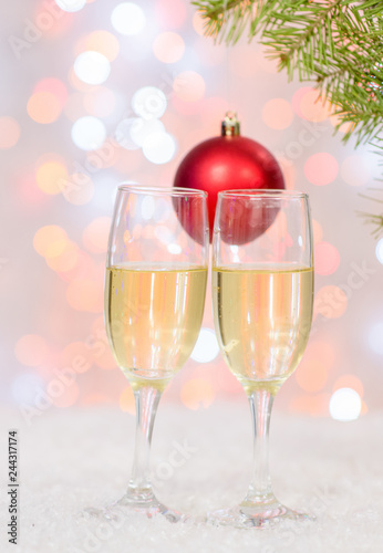 Glasses of champagne with Christmas decorations on festive background
