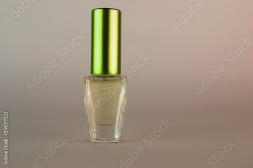 Transparent perfume bottle with green lid close up
