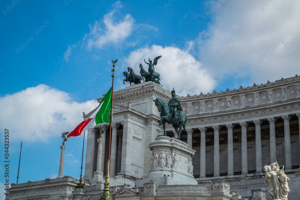 Obraz premium Rome, Italy. Famous Vittoriano with gigantic equestrian statue of King Vittorio Emanuele II with italian flag in front of it