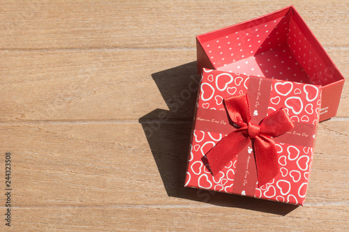 Lovely Gift box with red bow ribbon on rustic background for Valentines day