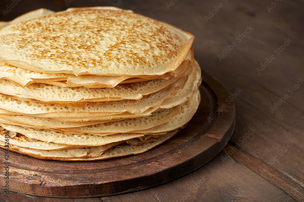 Stack of russian pancake blini on a wooden background - obrazy, fototapety, plakaty 