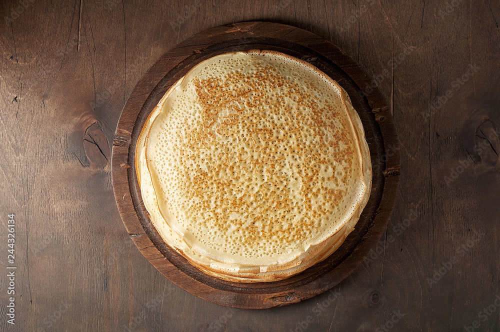 Stack of russian pancake blini on a wooden background