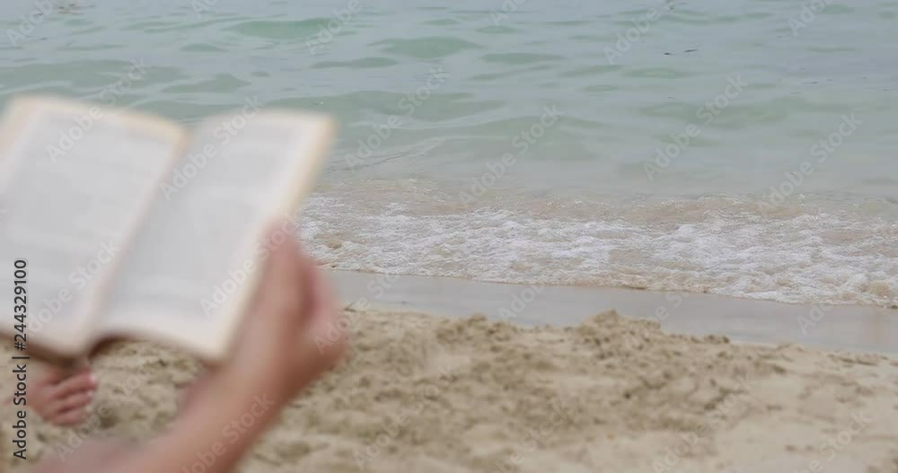 Female hands with a book on the seashore in the summer. Female hands with a book on the seashore in the summer.