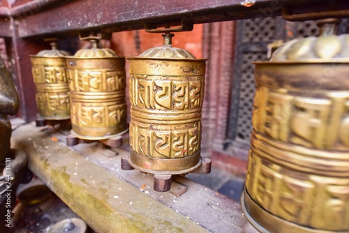 Fototapeta Naklejka Na Ścianę i Meble -  Golden Tibetan Prayer Wheels at Patan Golden Temple in Nepal