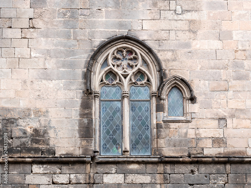 Traditional ancient gothic style window. Old vintage window on stone wall.
