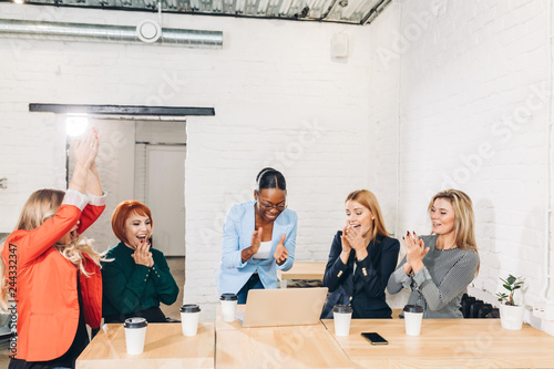 Fotografia diversity, race, height, success and people concept - multi-ethnic group of happy women clapping hands and giving high five at jubilation at her success or victory