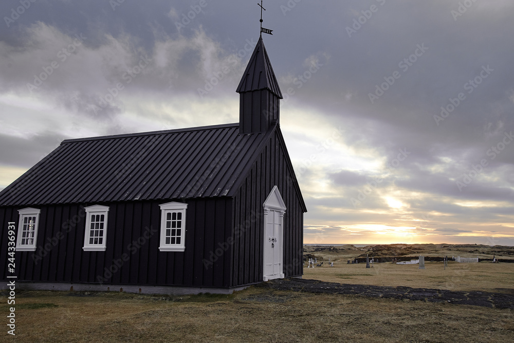 Fototapeta premium Famous picturesque black church of Budir at Snaefellsnes peninsula region in Iceland during strong wind and dramatic sky