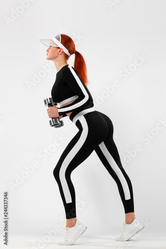 Sporty fit woman, athlete with dumbbells makes fitness exercising on white background.