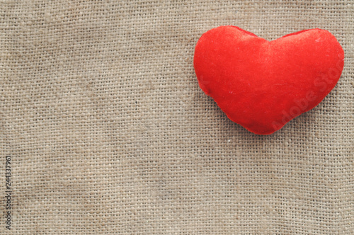 Vintage rustic love card for Valentine's day-red plush heart on burlap. closeup. top view. tinted. Shabby chic
