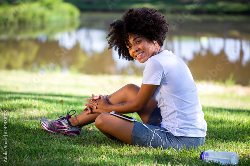 Portrait of a young african american woman listening to music on cell phone - Imagem
