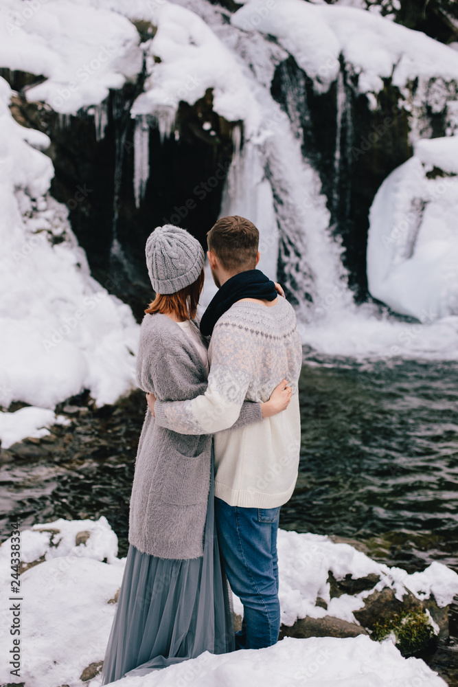 couple against the backdrop of a waterfall couple against the backdrop of a waterfall