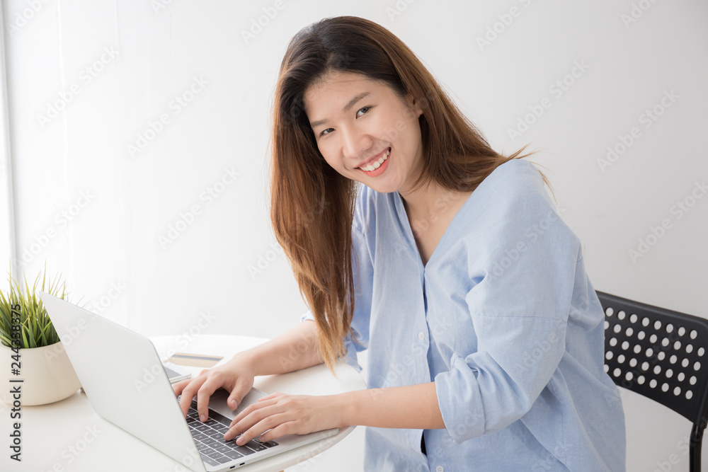 Asian women wearing casual dresses using computer laptop on desk at home, Concepts lifestyle and self study Asian women wearing casual dresses using computer laptop on desk at home, Concepts lifestyle and self study