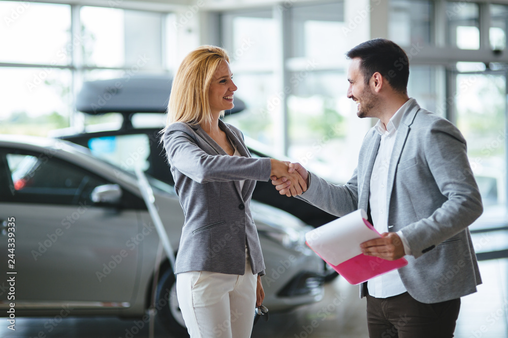Professional salesperson during work with customer at car dealership. Professional salesperson during work with customer at car dealership.