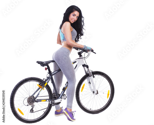 Woman on a bicycle dressed in a sports uniform in gray in the studio on a white background