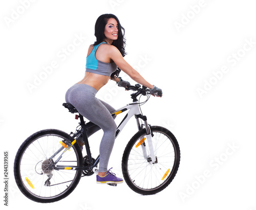Woman on a bicycle dressed in a sports uniform in gray in the studio on a white background
