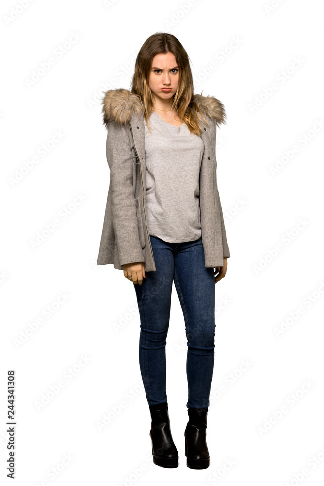 A full-length shot of a Teenager girl with coat with sad and depressed expression on isolated white background A full-length shot of a Teenager girl with coat with sad and depressed expression on isolated white background