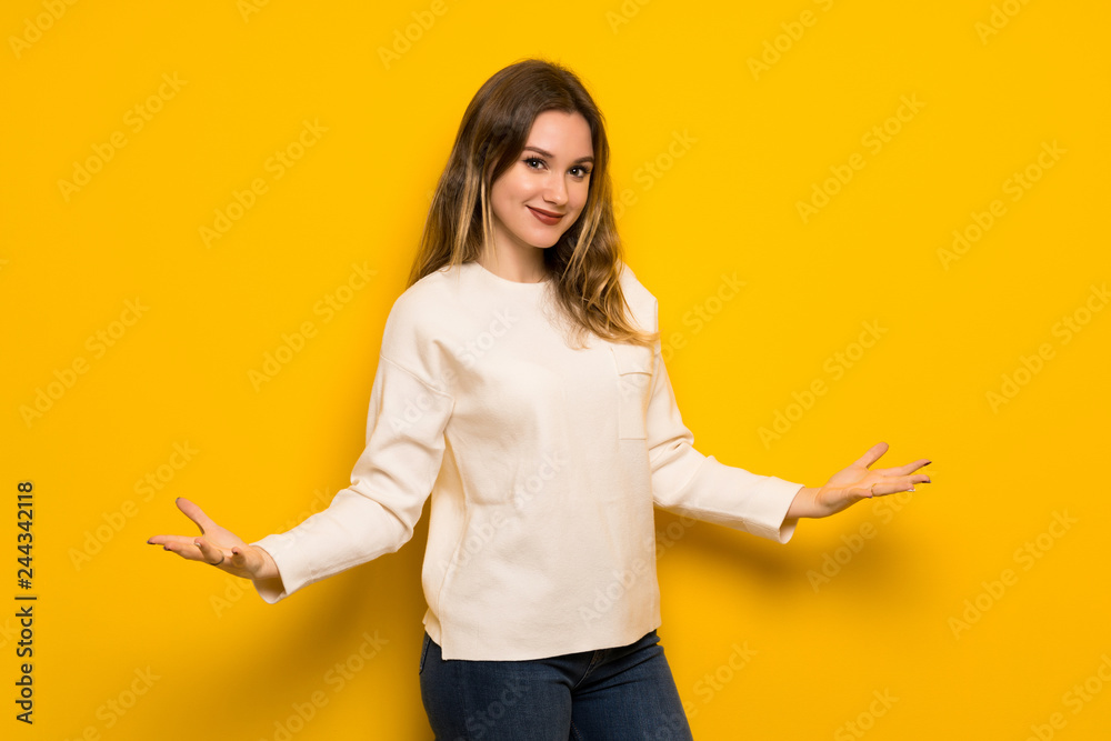 Teenager girl over yellow wall proud and self-satisfied in love yourself concept Teenager girl over yellow wall proud and self-satisfied in love yourself concept